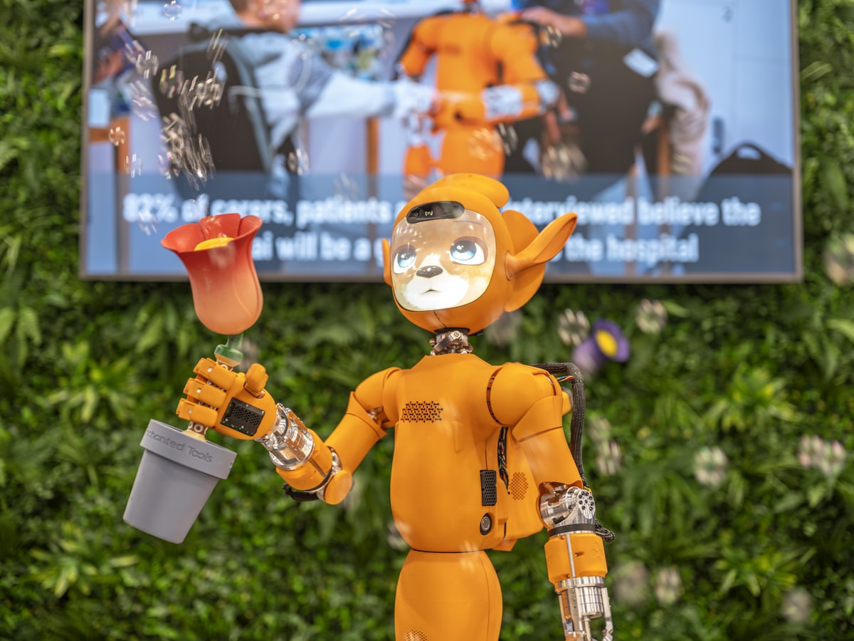 Orange robot holding a potted plant with a flower.