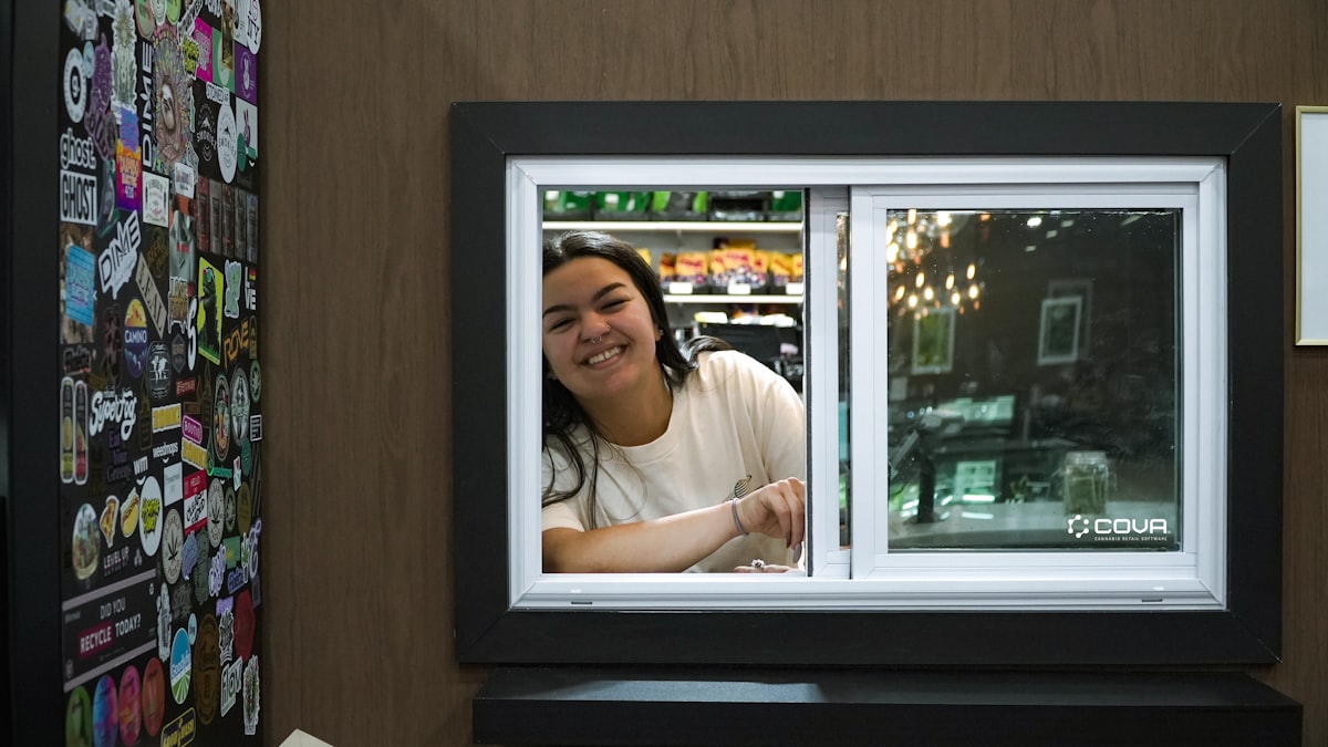 A smiling woman looks out of a window.