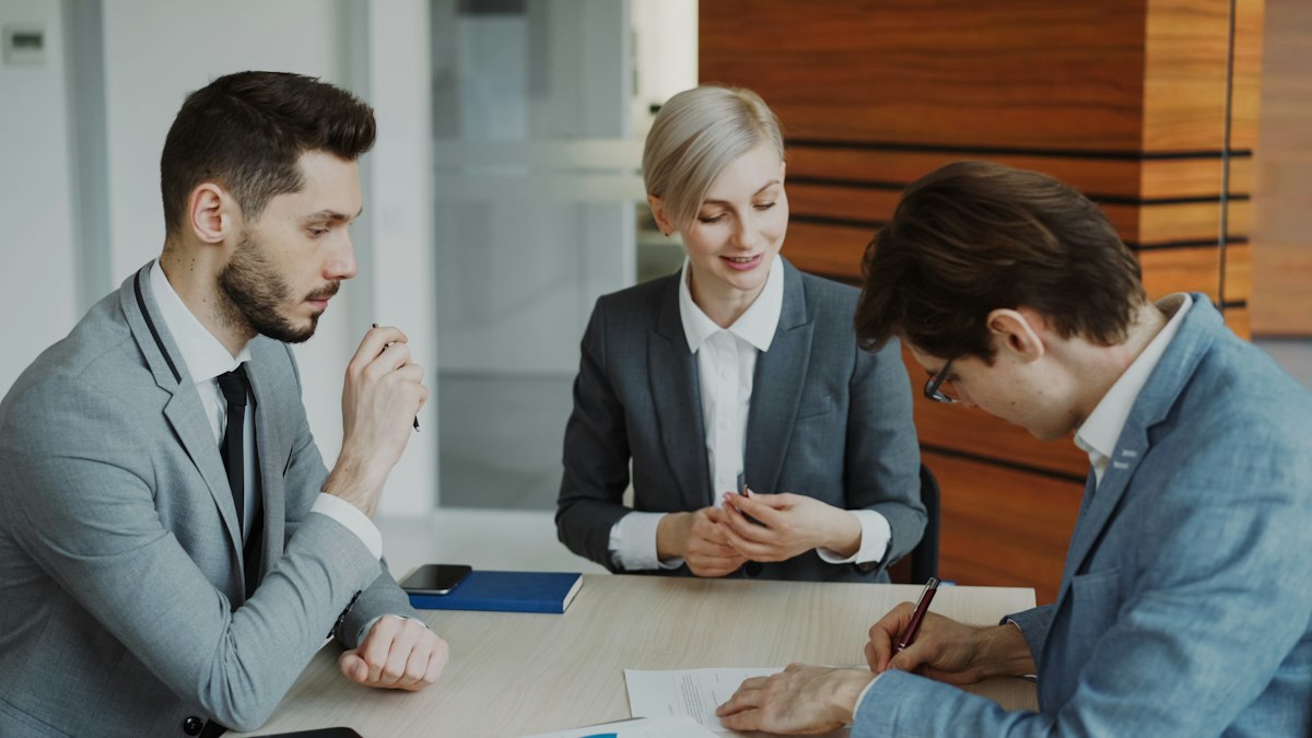 Pessoas de negócios assinando um contrato em uma mesa